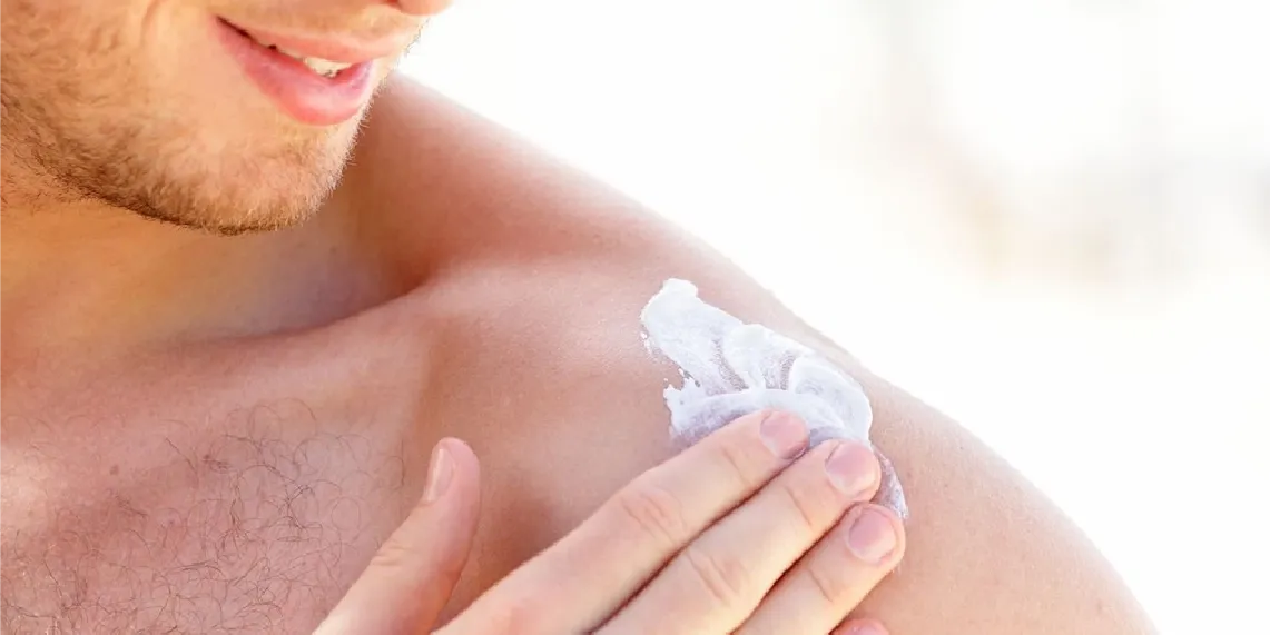 Man applying sunscreen to shoulder for skin cancer prevention