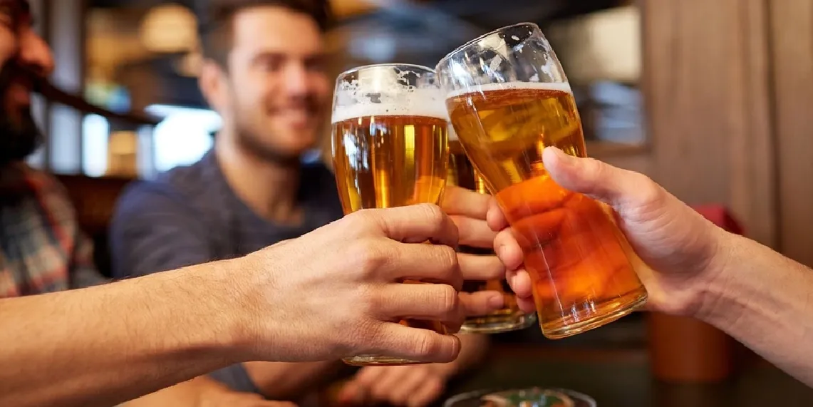 Men toasting with beer glasses at a bar