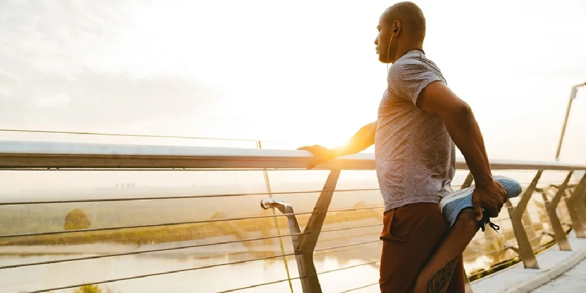Man stretching outdoors at sunrise before exercise