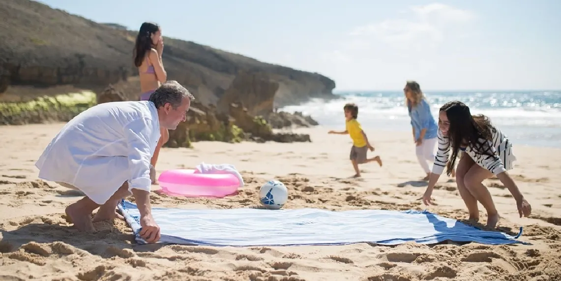 Family enjoying summer beach day showing balanced approach to healthy outdoor sun exposure for the whole family