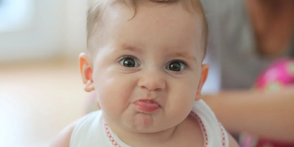 Baby making expressive straining face showing normal infant dyschezia rather than true constipation