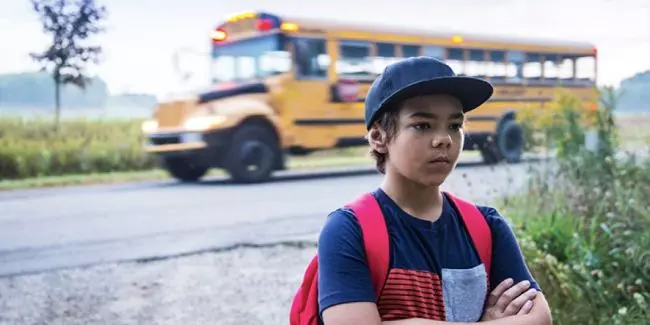 Nervous child at the bus stop experiencing back to school anxiety