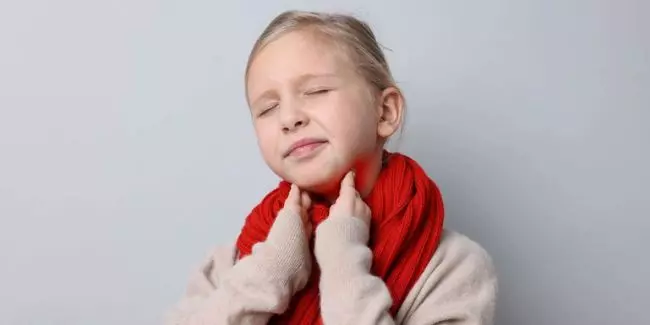Child with sore throat wearing scarf