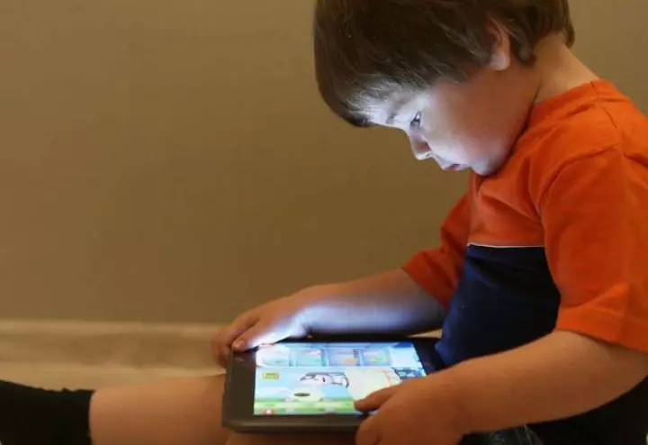 Young-boy-using-brightly-lit-tablet-in-low-light-showing-why-screen-free-bedrooms-matter-for-children_s-sleep-Image.jpg