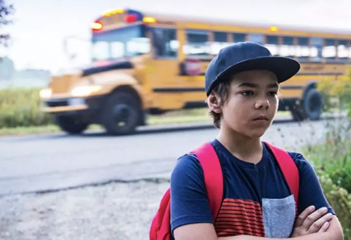 Nervous child at the bus stop experiencing back to school anxiety