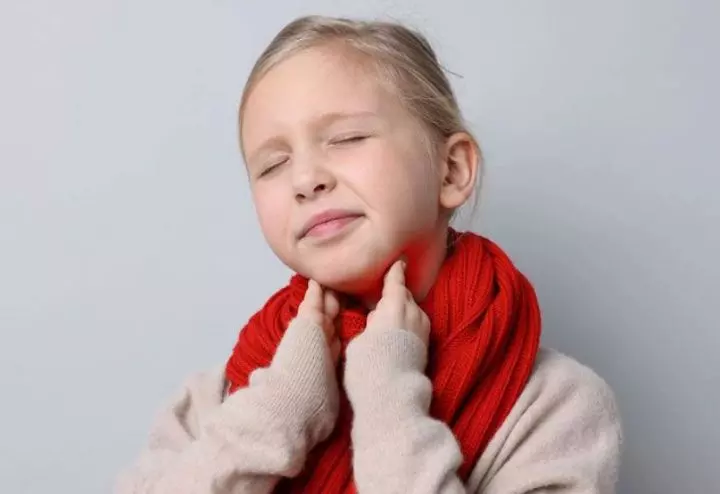 Child with sore throat wearing scarf