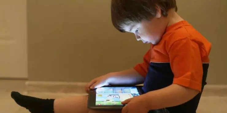 Young-boy-using-brightly-lit-tablet-in-low-light-showing-why-screen-free-bedrooms-matter-for-children_s-sleep-Image.jpg