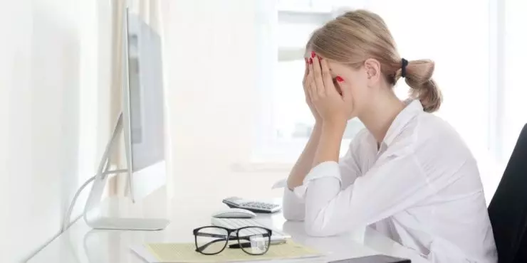 Woman feeling stressed while at her computer