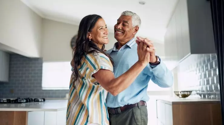 Active older couple dancing together to stay physically fit while aging