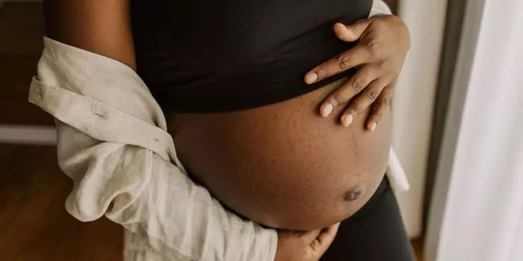 Pregnant woman holding her baby bump during pregnancy