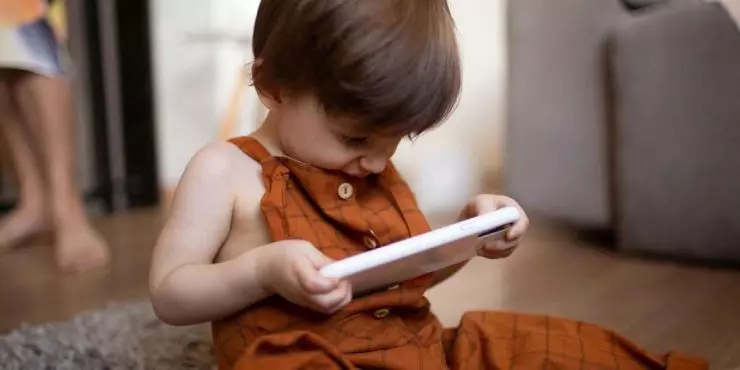Toddler-using-smartphone-alone-showing-why-AAP-screen-time-guidelines-matter-for-young-children.jpg
