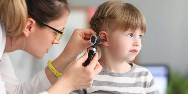 Doctor checking child’s ear for signs of ear infection