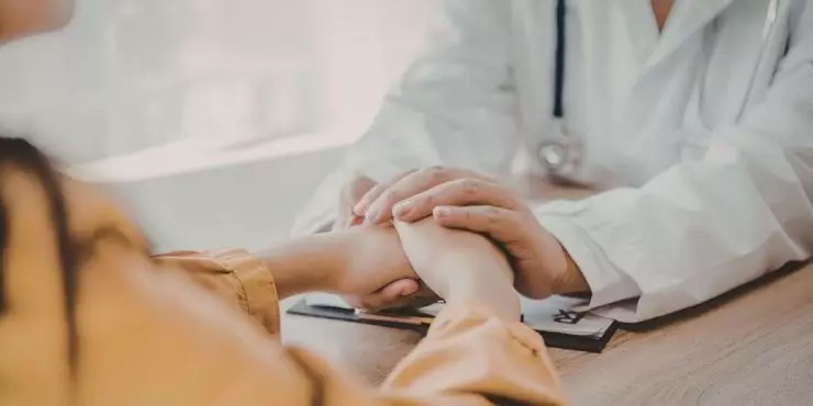 Doctor and patient holding hands