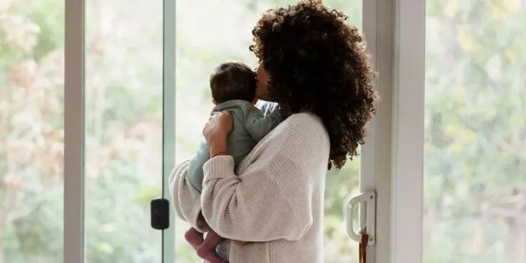 Mother holding baby near window
