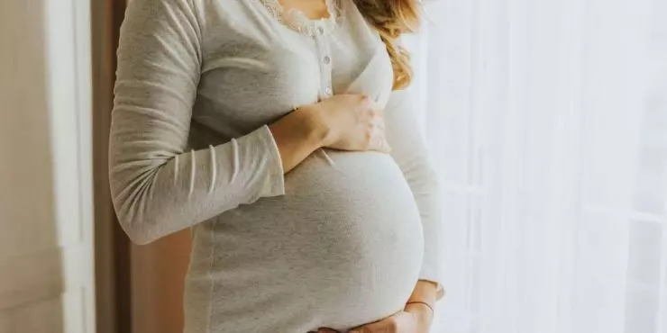 Pregnant woman holding her belly