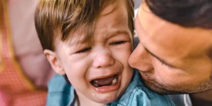 Father comforting crying toddler during emotional meltdown