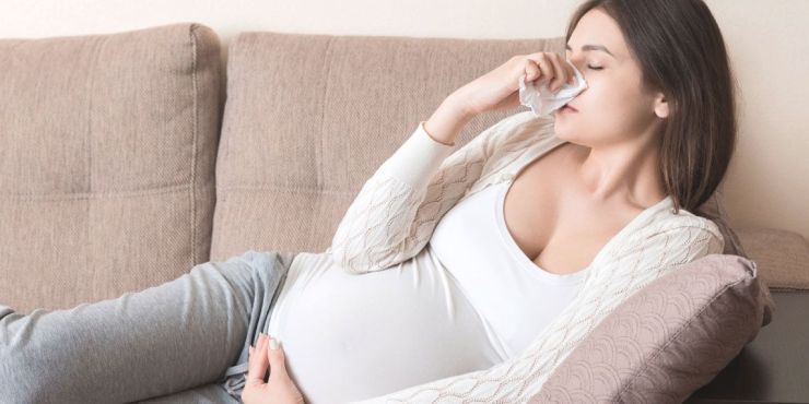 pregnant-woman-cold-blowing-nose-in-bed..jpg
