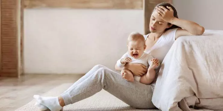 Tired-mom-comforting-a-suddenly-fussy-baby-at-home.jpg