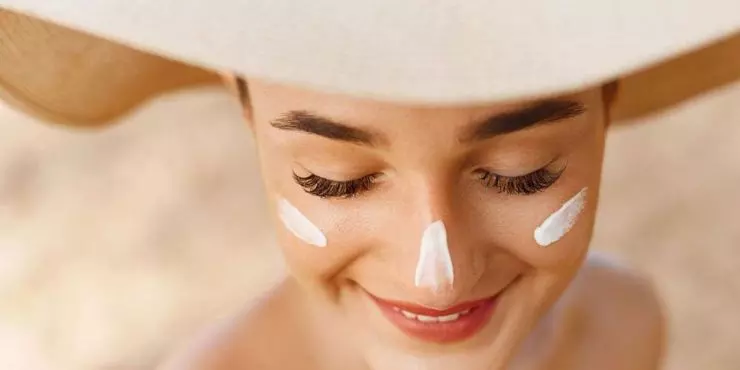Woman-with-wide-brimmed-hat-and-sunscreen-on-face-showing-daily-skin-cancer-prevention-habits.jpg