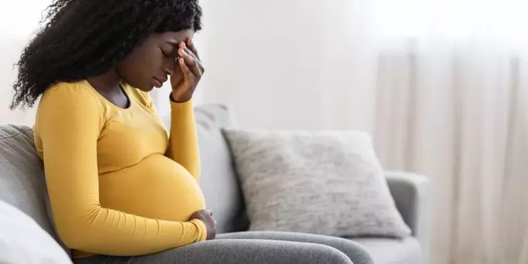 Image1-pregnant-woman-sitting-headache-stress-couch.jpg